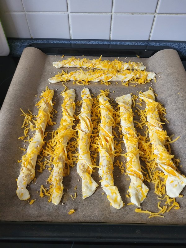 Mit Cheddar und Sesam bestreut